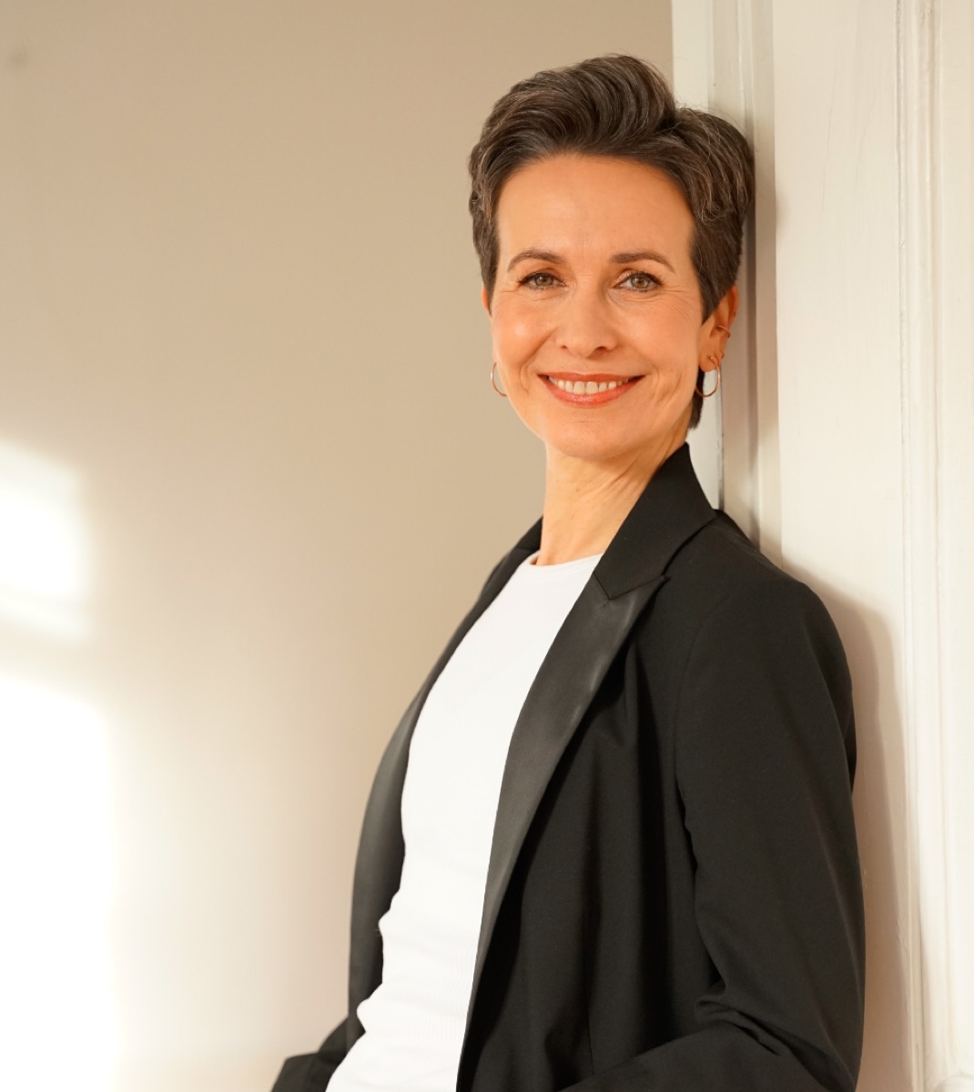 Shila Driesch, an eine weiße Tür gelehnt